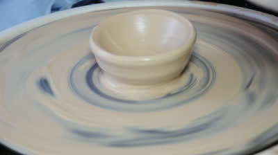 stock-footage-kid-shaping-of-clay-on-pottery-wheel-and-wetting-hands